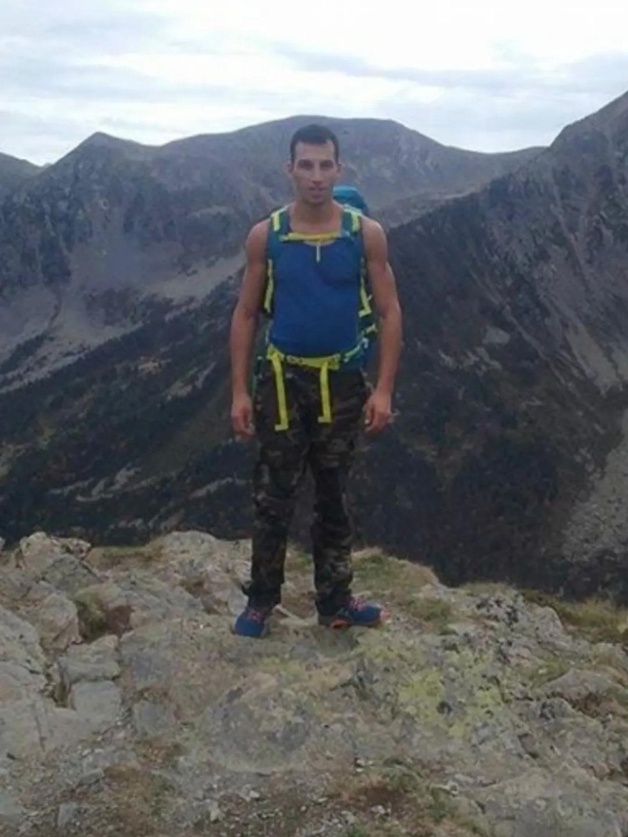 Juan en haut d'une crête, sac de randonnée sur le dos, cirque de montagne en arrière-plan