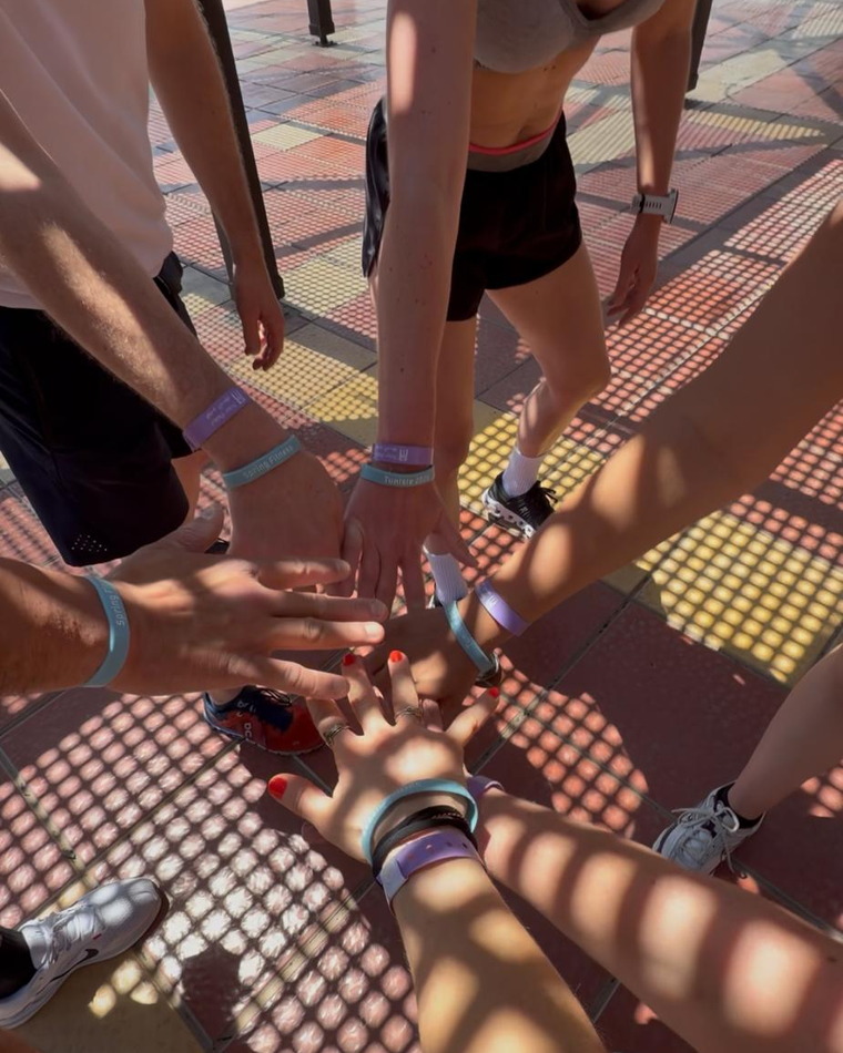 Des poignets réunis au centre du cercle, portant les bracelets du séjour