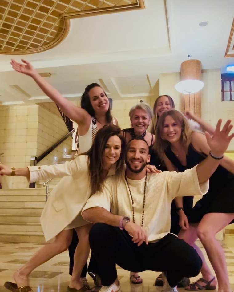 Le groupe qui éclate de rire dans le hall de l'hôtel, bras tendus