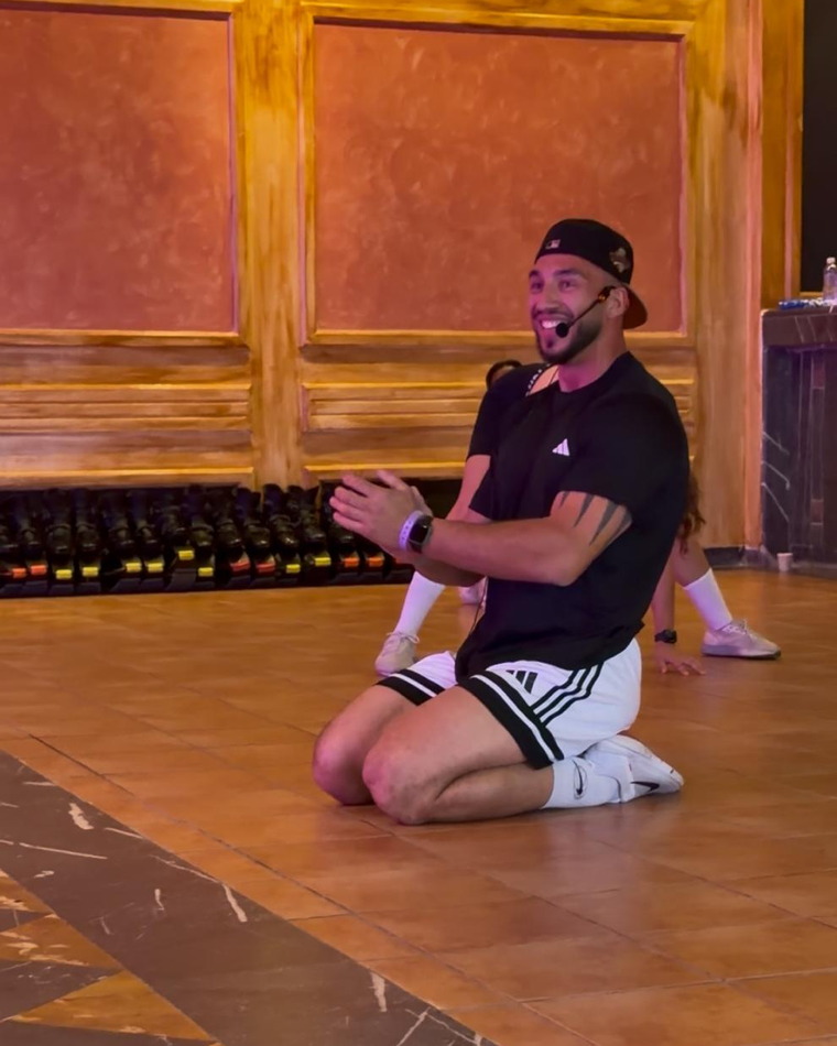 Juan à genoux sur le parquet de la salle, bras croisés, en fin de série